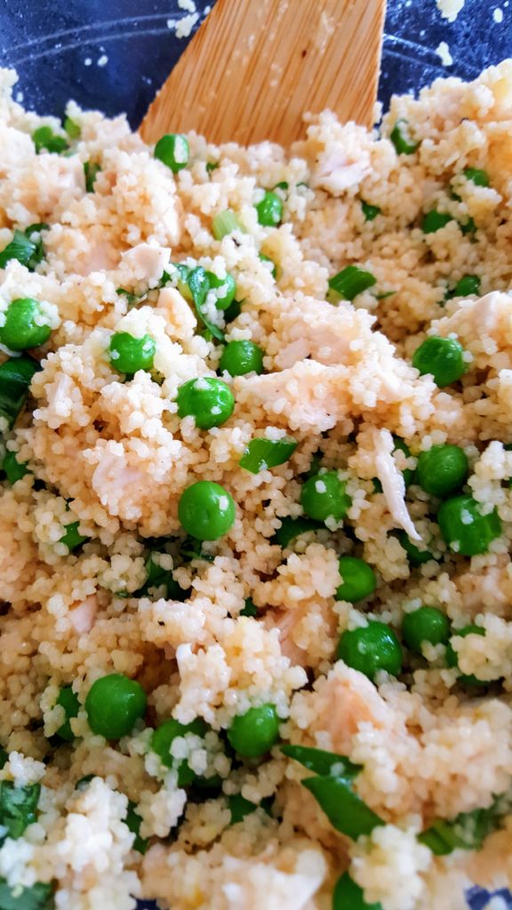 A close up photo of couscous with peas and chicken