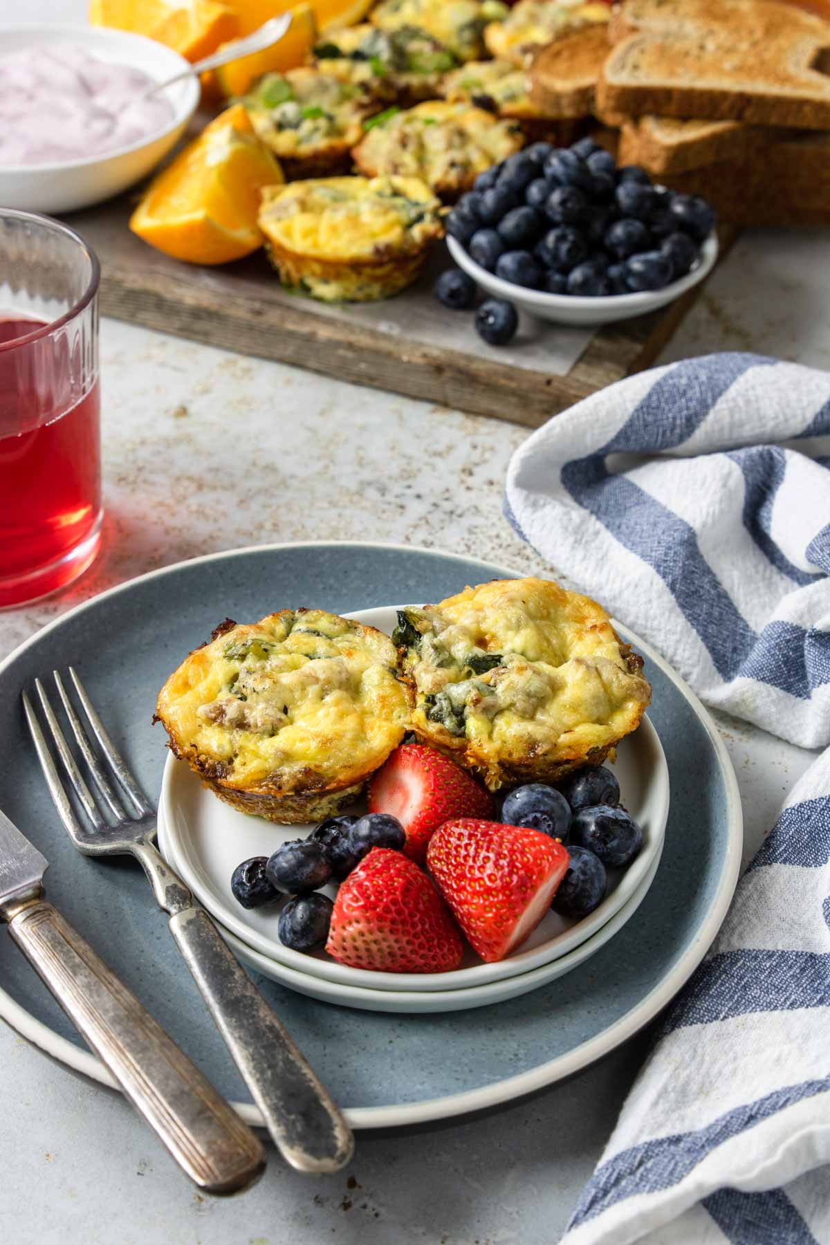 sausage egg muffins on a plate with fresh fruit