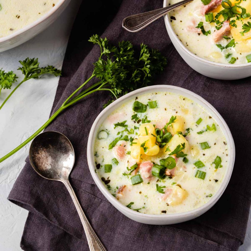 ham chowder in a white bowl on a gray napkin