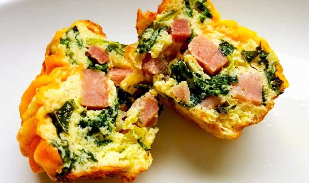 ham and kale egg cup split open so you can see the ham and kale inside