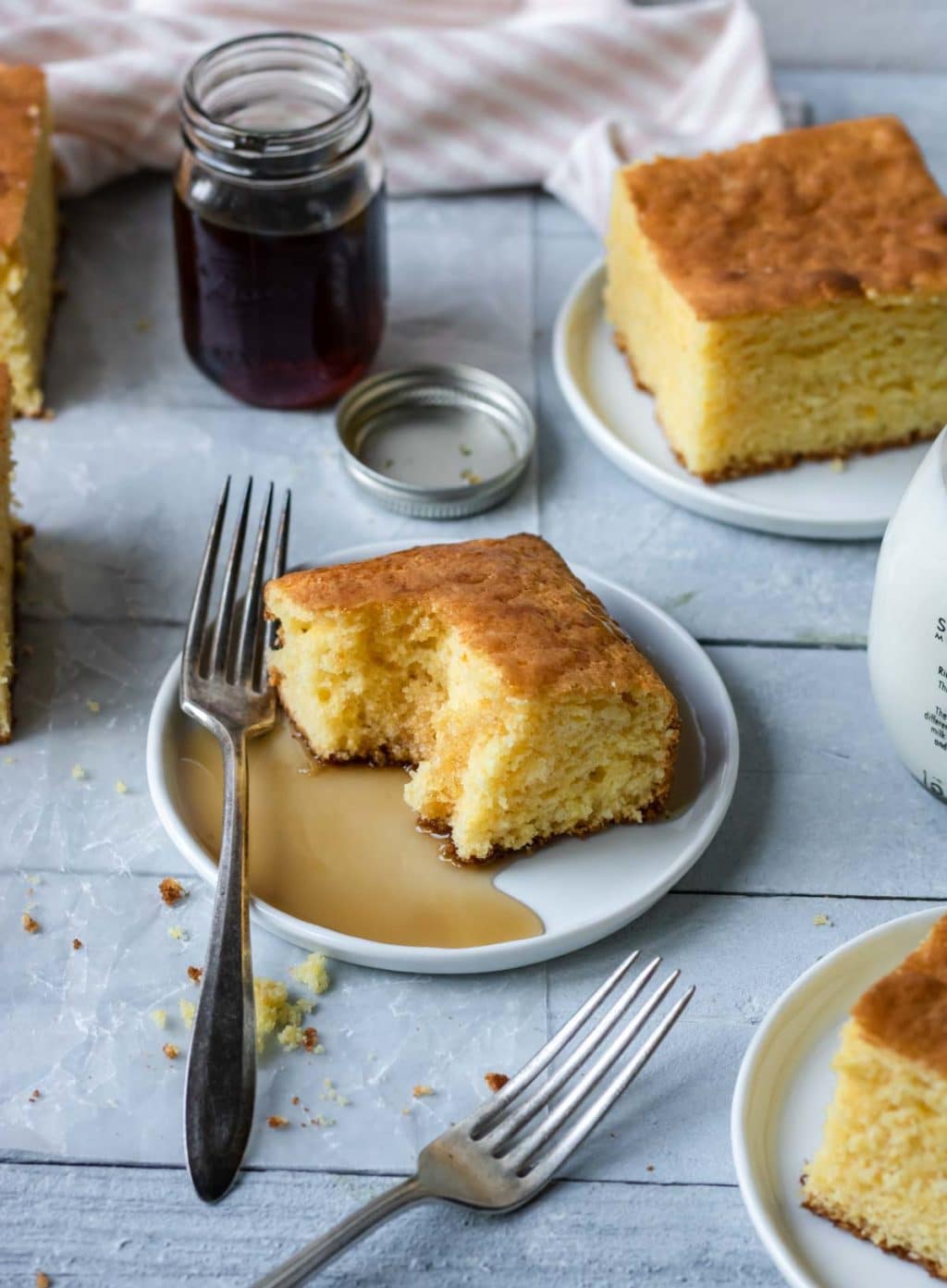 a couple plates of cornbread made with yellow cake mix, drizzled with syrup and honey