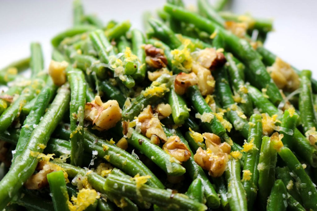 green beans topped with nuts and lemon zest