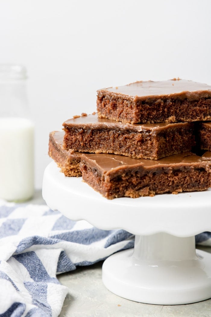 Chocolate sheet cake cut into squares and placed on a cake pedestal