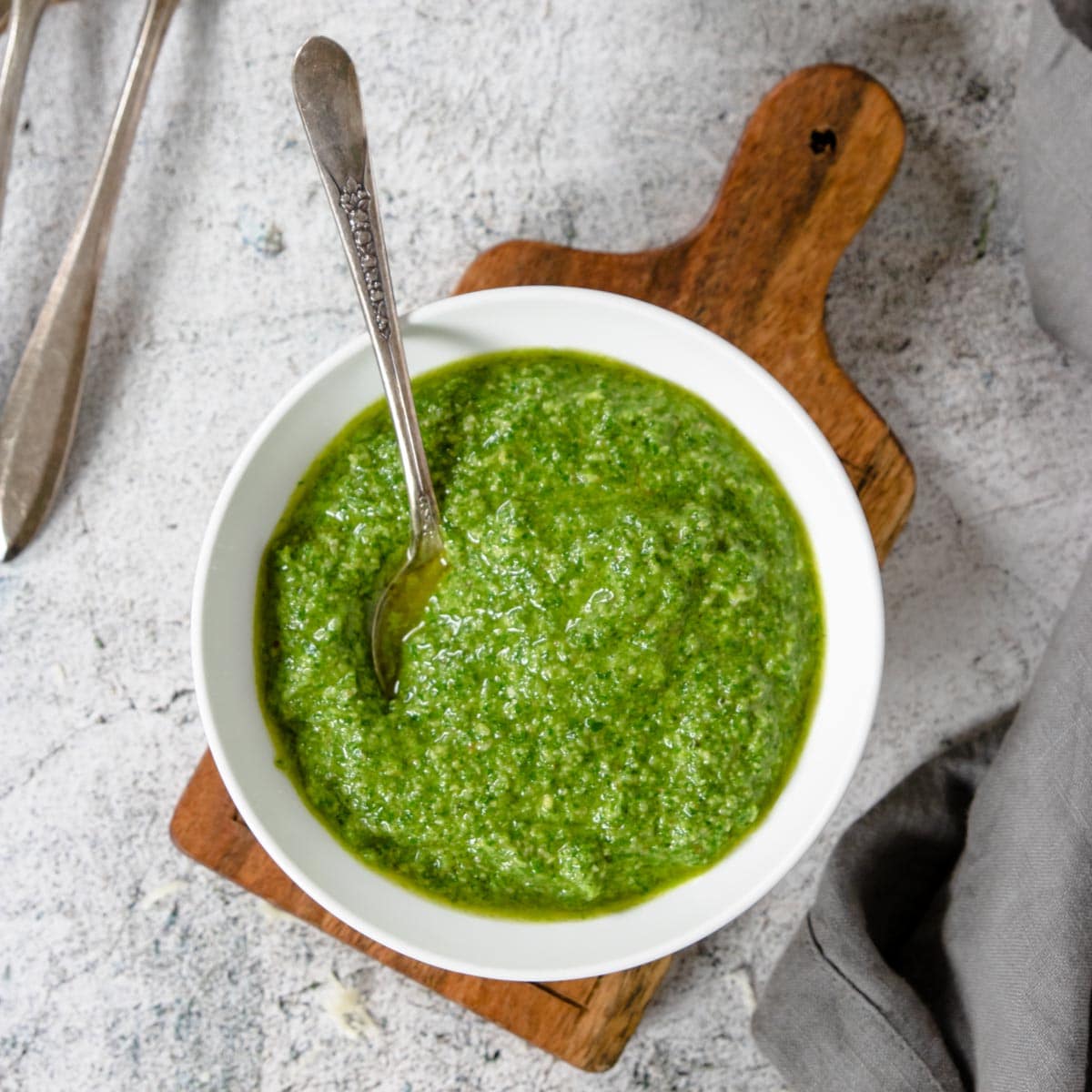 Fresh Basil Pesto in a bowl on a cutting board