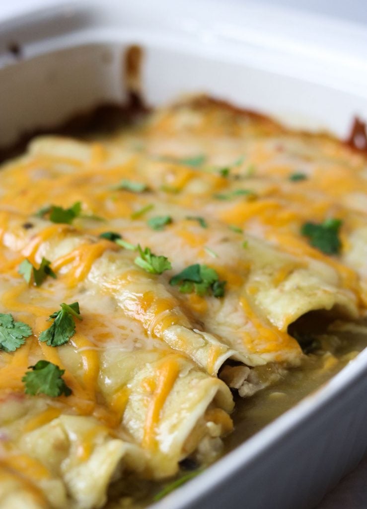 Verde Chicken Enchiladas in a white casserole dish