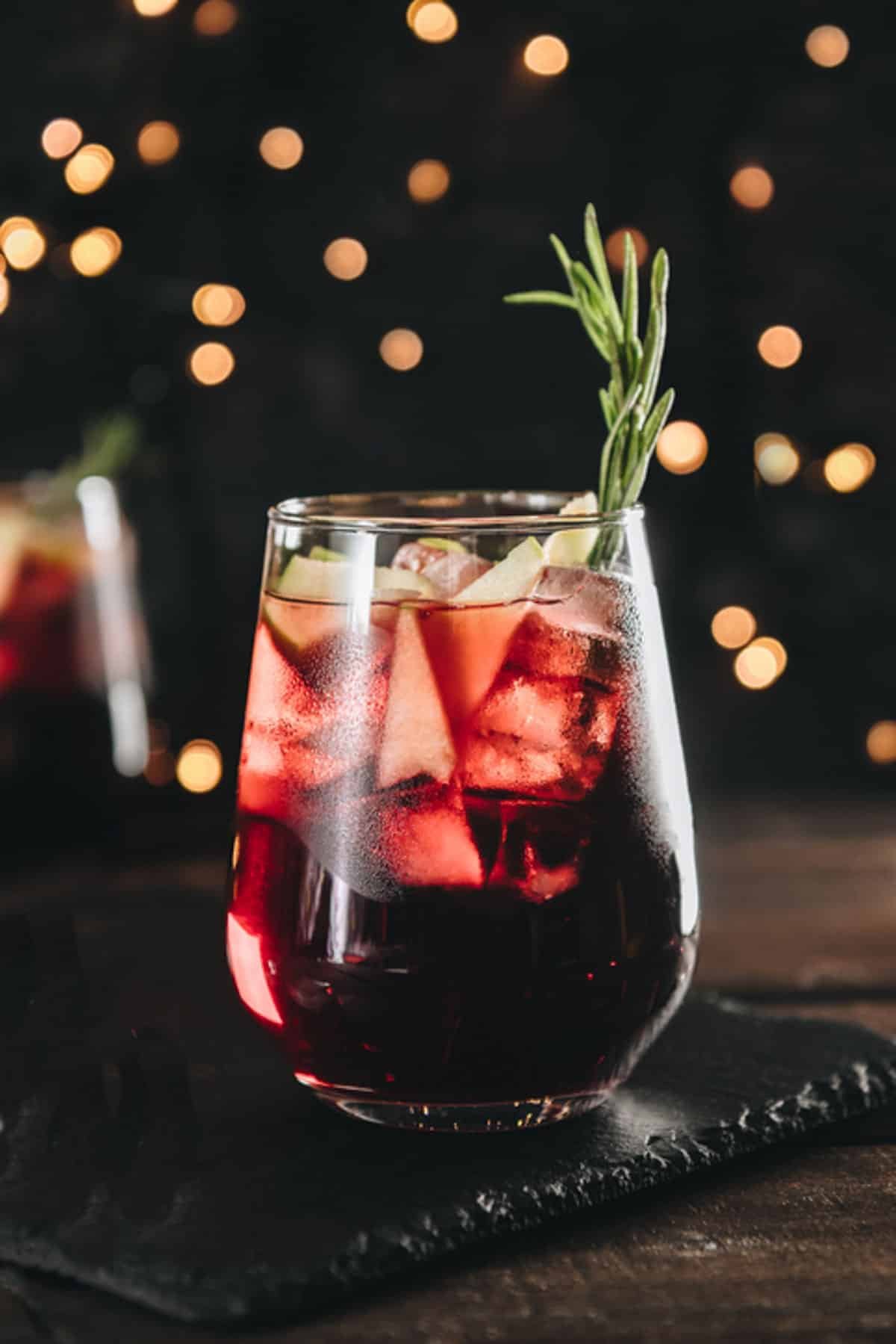 red wine winter sangria on a table with twinkle lights in the background 