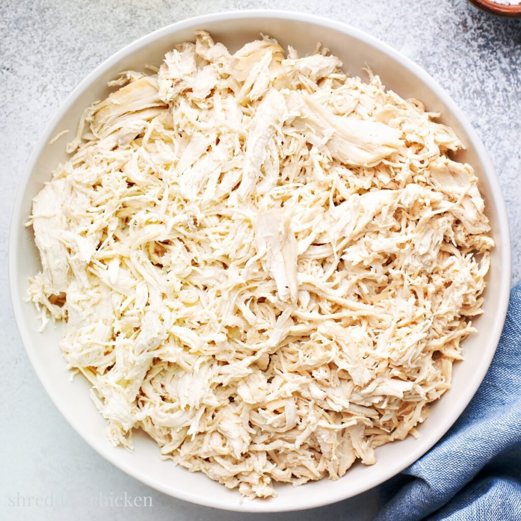 a large white bowl full of shredded chicken that was cooked in the Instant Pot