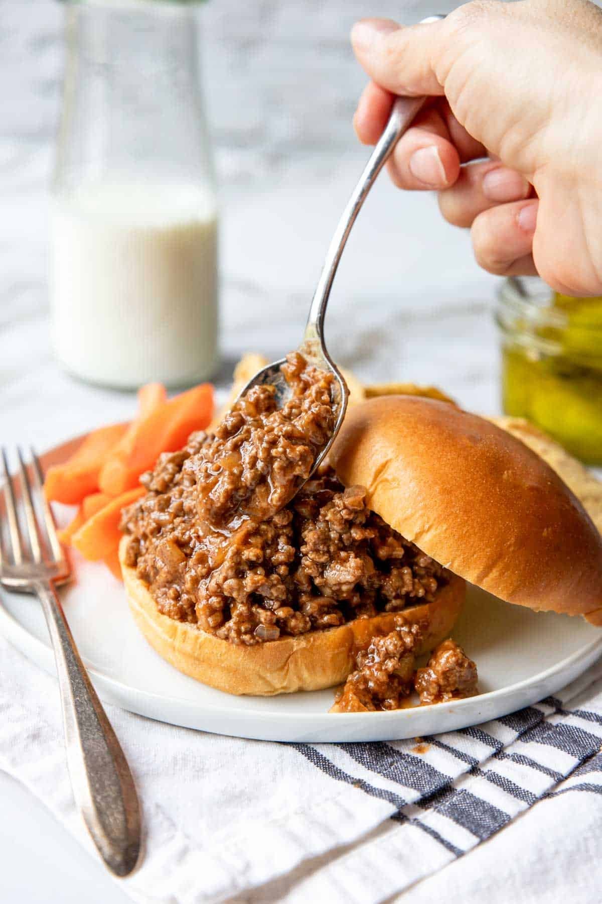 Ground Beef Sloppy Joe's being spooned onto a bun