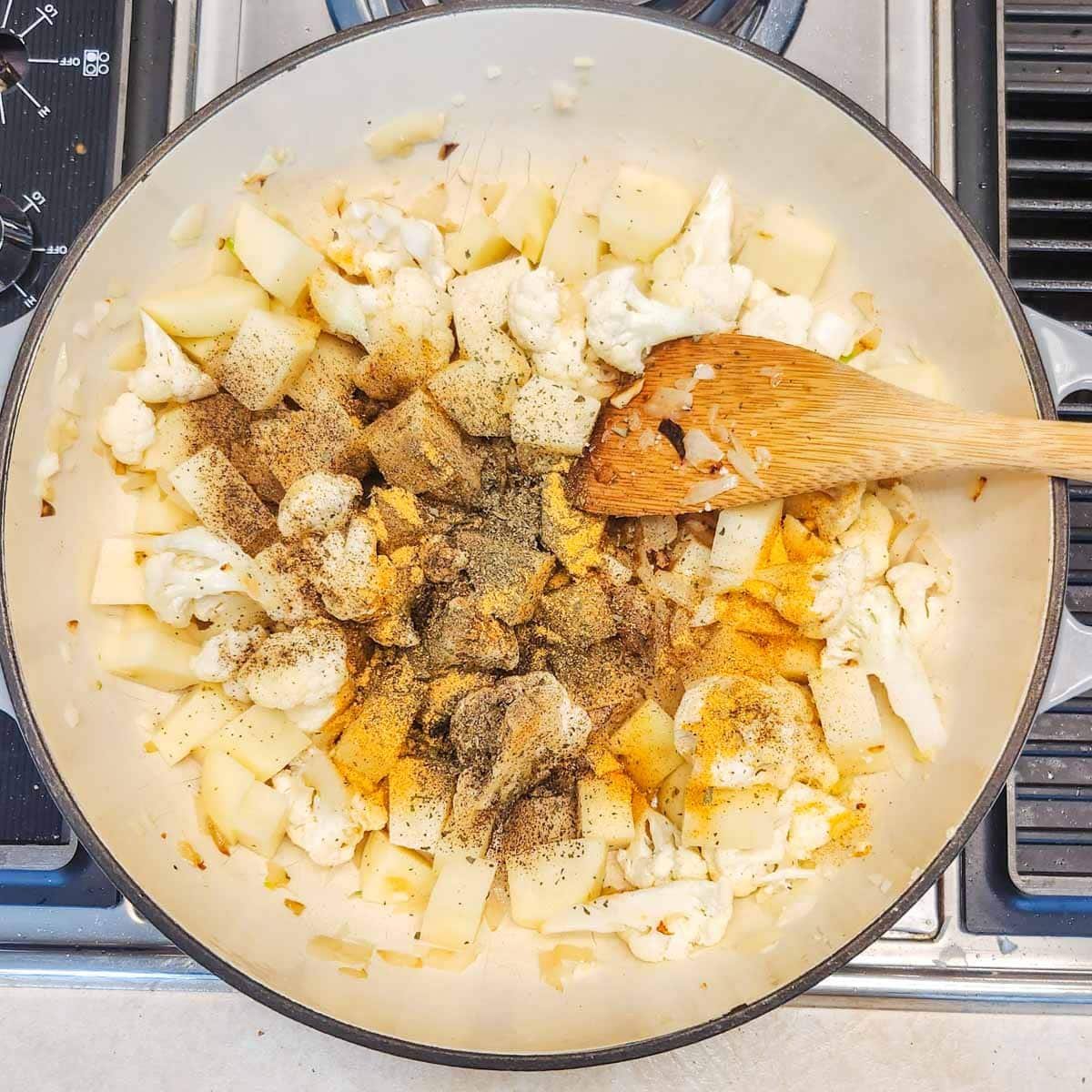 cauliflower, potatoes, and spices in a pot