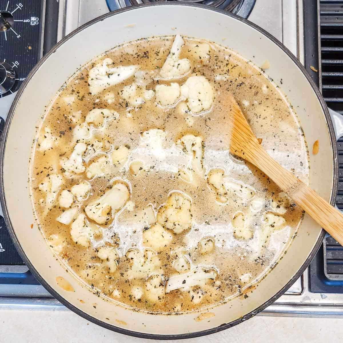 making cauliflower potato soup in a large pot