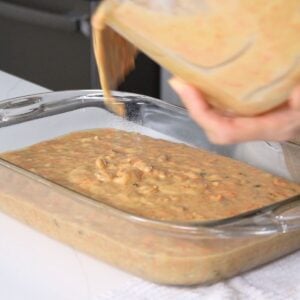 pouring carrot cake batter in a 9x13 baking pan