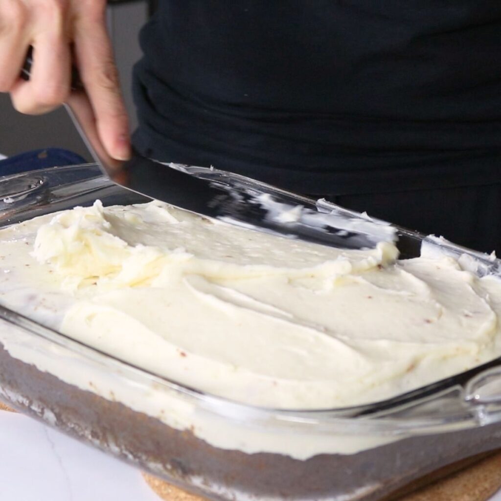 icing a carrot cake with cream cheese buttercream