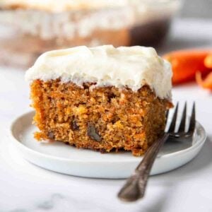 a piece of carrot cake with frosting on a small plate
