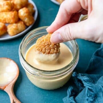 a chicken nugget dipping into homemade honey mustard dip