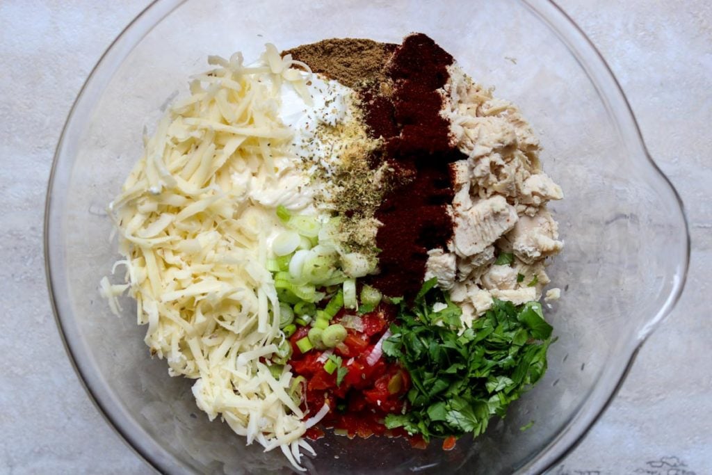 Creamy Chicken Taco filling ingredients all separate in a glass mixing bowl