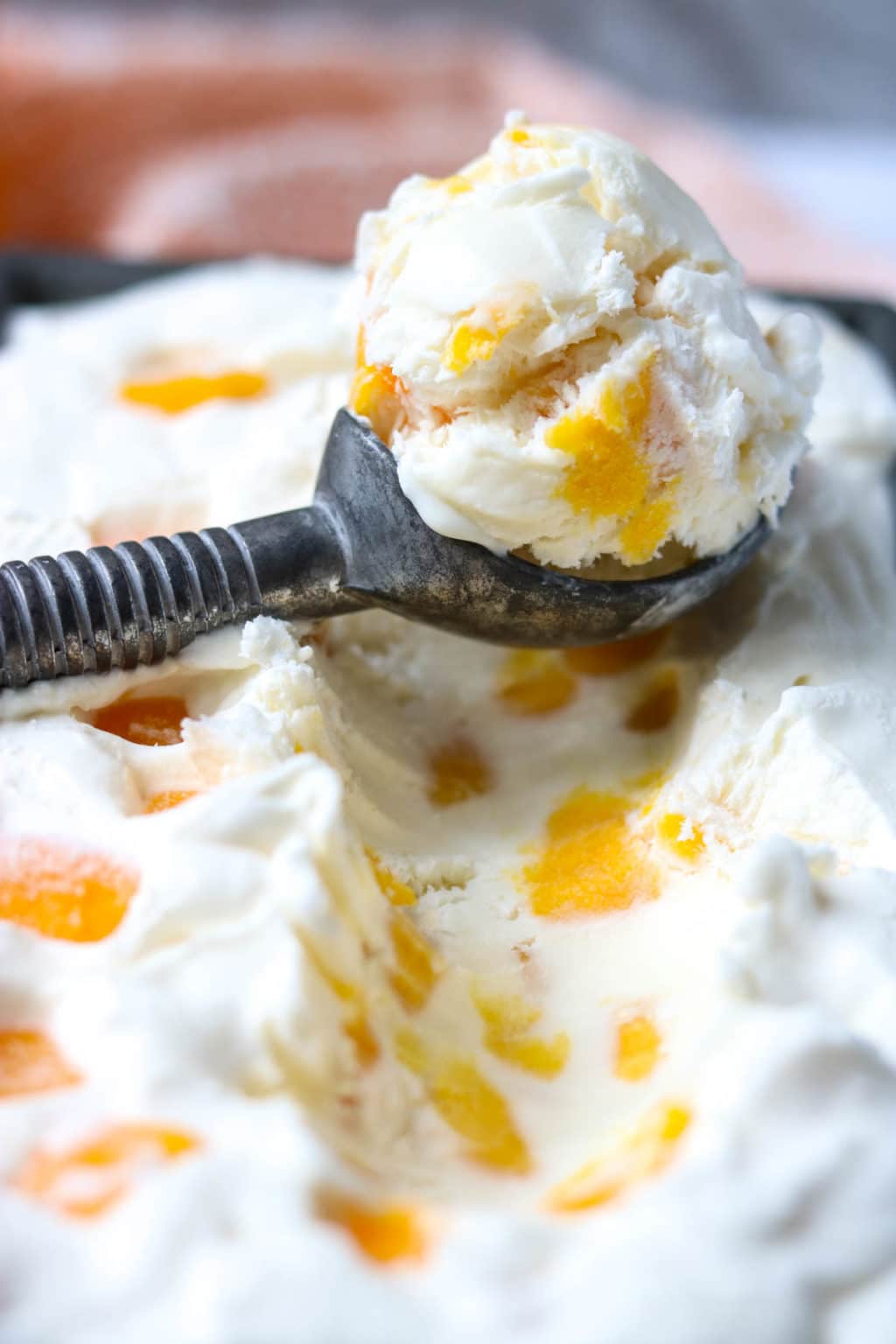 an ice cream scoop full of mango ice cream
