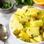 fresh pineapple side dish in a bowl garnished with cilantro