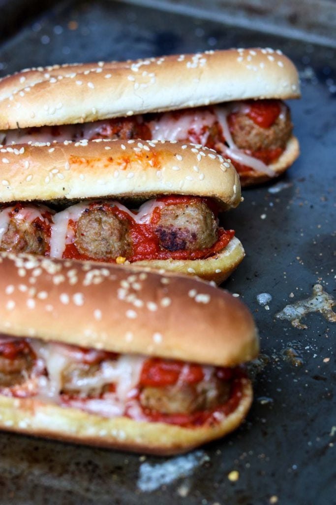 Meatball subs topped with marinara and cheese