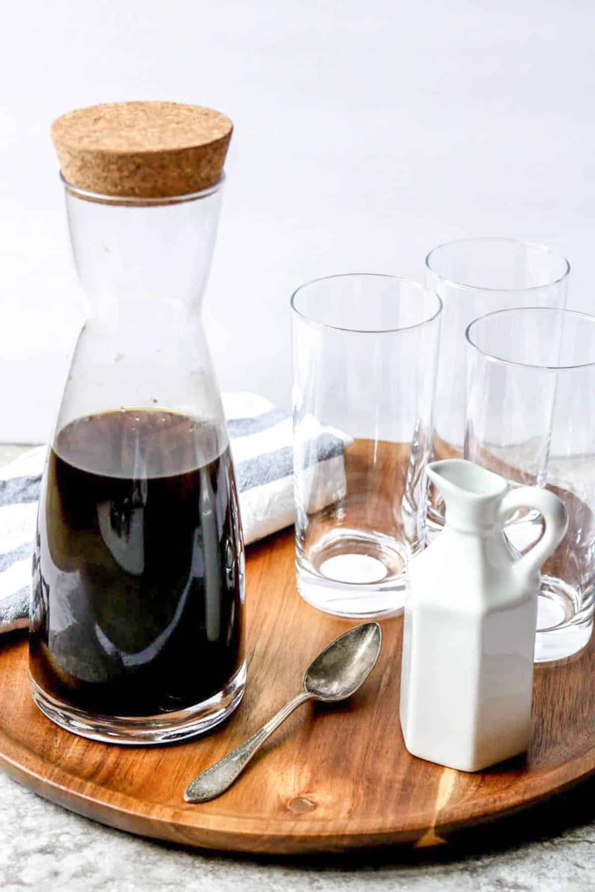 a pitcher of cold brew coffee with glasses to the side