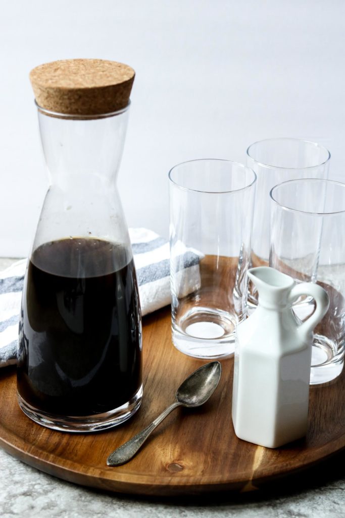 a tray with a coffee carafe three glasses and a milk carafe