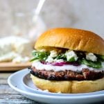 greek turkey burger on a plate topped with feta cheese and spinach