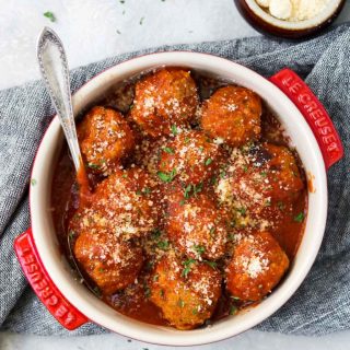 a round casserole dish with turkey meatballs and sauce