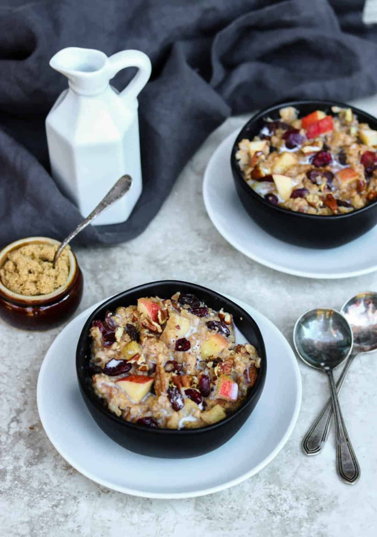 two bowls of oatmeal loaded with fruit and nuts