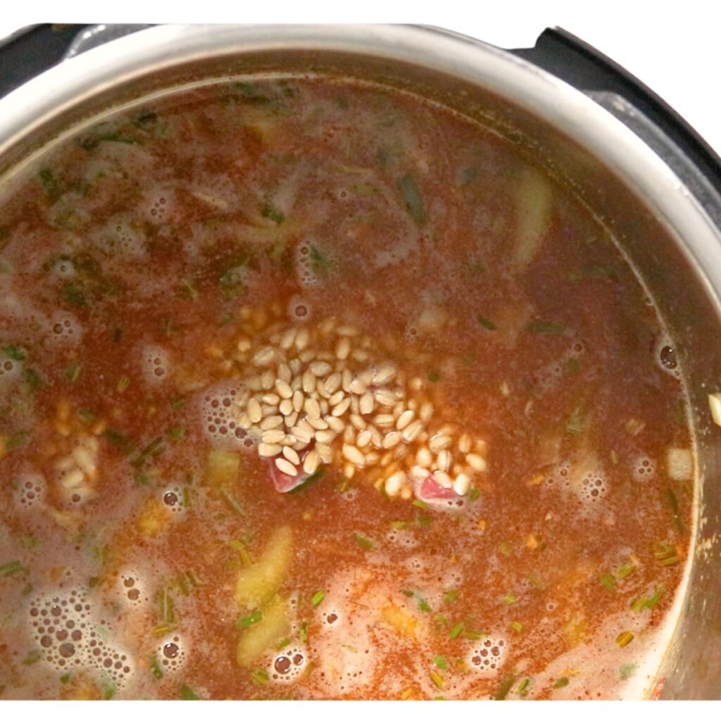 Beef broth and barley added to the Instant Pot while making Instant Pot Beef and Barley Stew