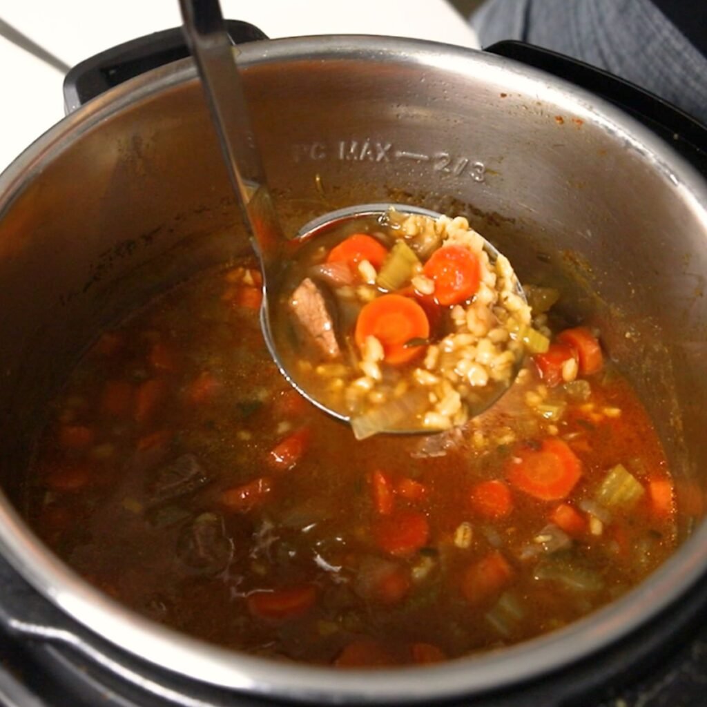 Beef and Barley Stew being ladled out of the Instant Pot