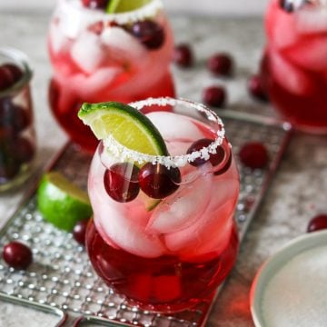 cranberry ginger margarita in a glass with salt on the rim