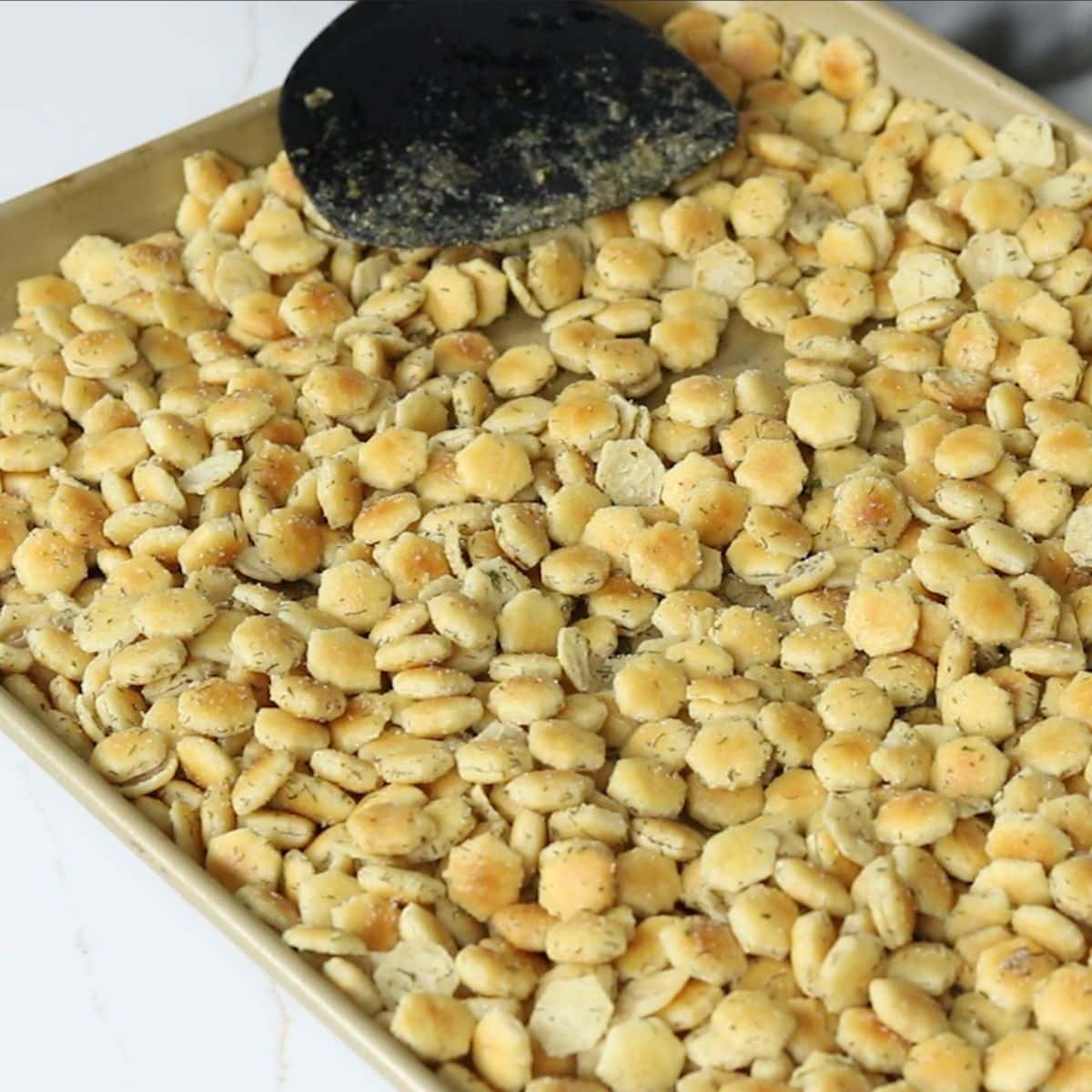 Seasoned Oyster crackers on a rimmed baking sheet