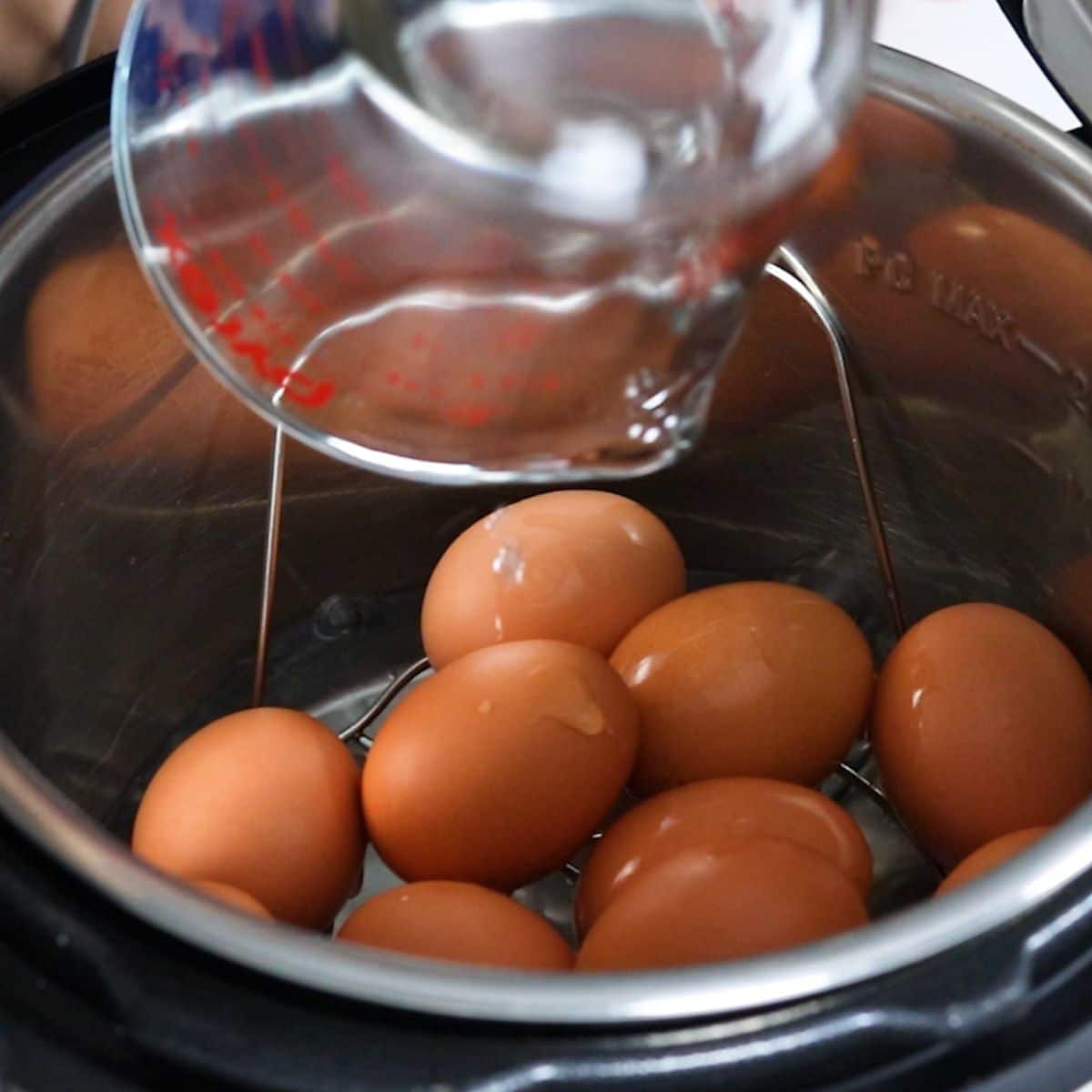 eggs in an Instant Pot with water being poured in