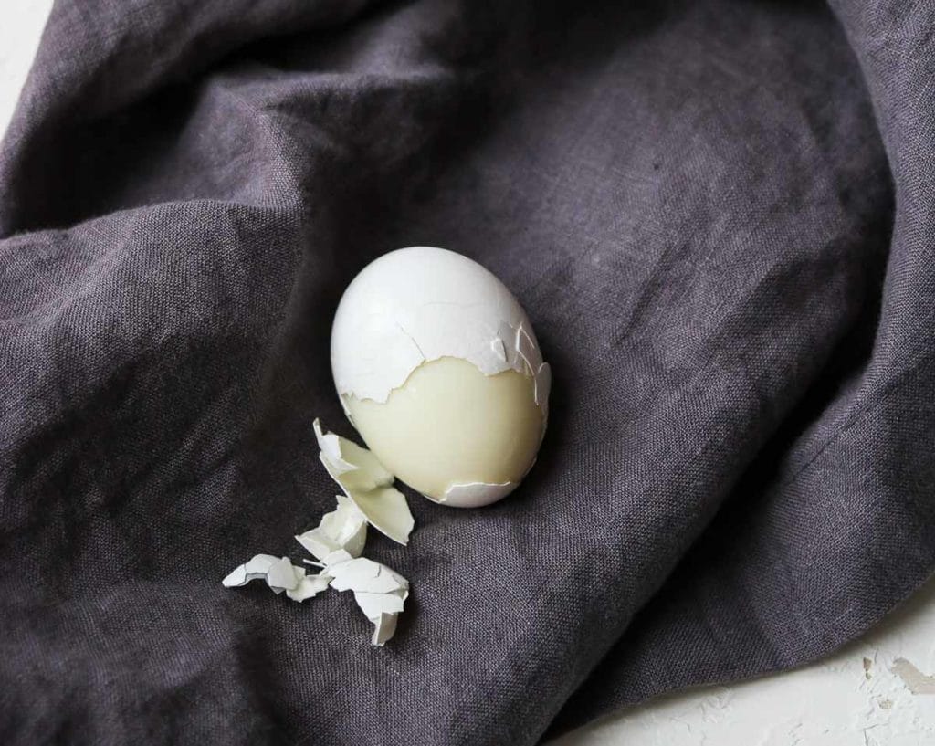 An Instant Pot Hard Boiled Egg, half peeled