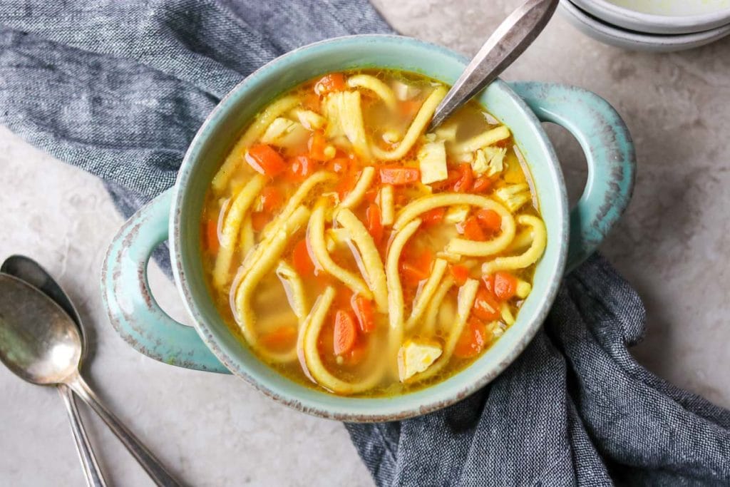 A green soup urn full of Kid Friendly Chicken Noodle Soup