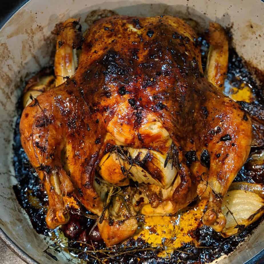 Perfect Roast Chicken in a dutch oven with herbs and veggies