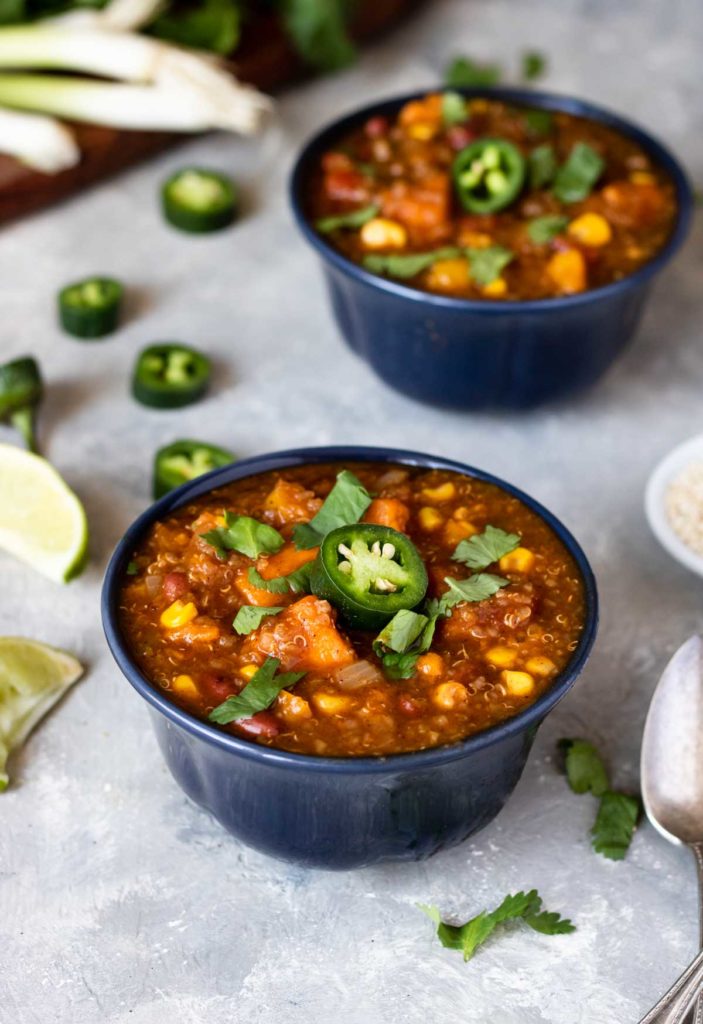 Instant Pot Quinoa Sweet Potato Chili in blue bowl garnished with cilantro and jalapenos