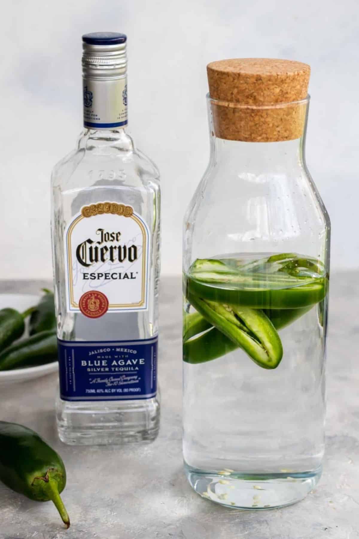 jalapeno tequila in a bottle with a bottle of jose cuervo in the background