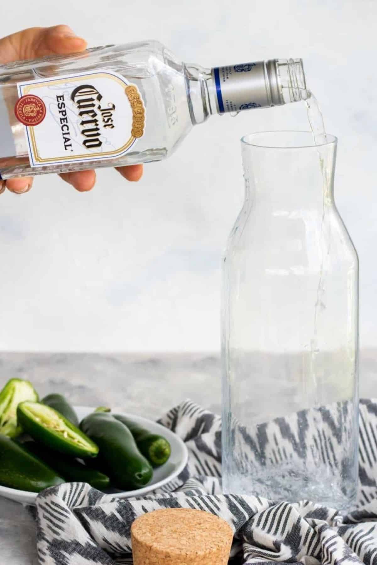 pouring tequila into a glass bottle