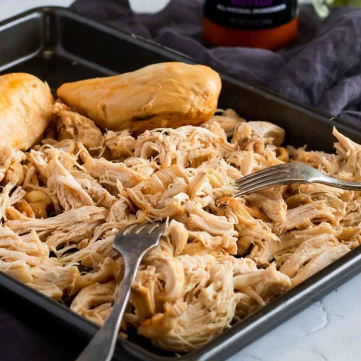 buffalo chicken cooked in the instant pot being shredded with two forks