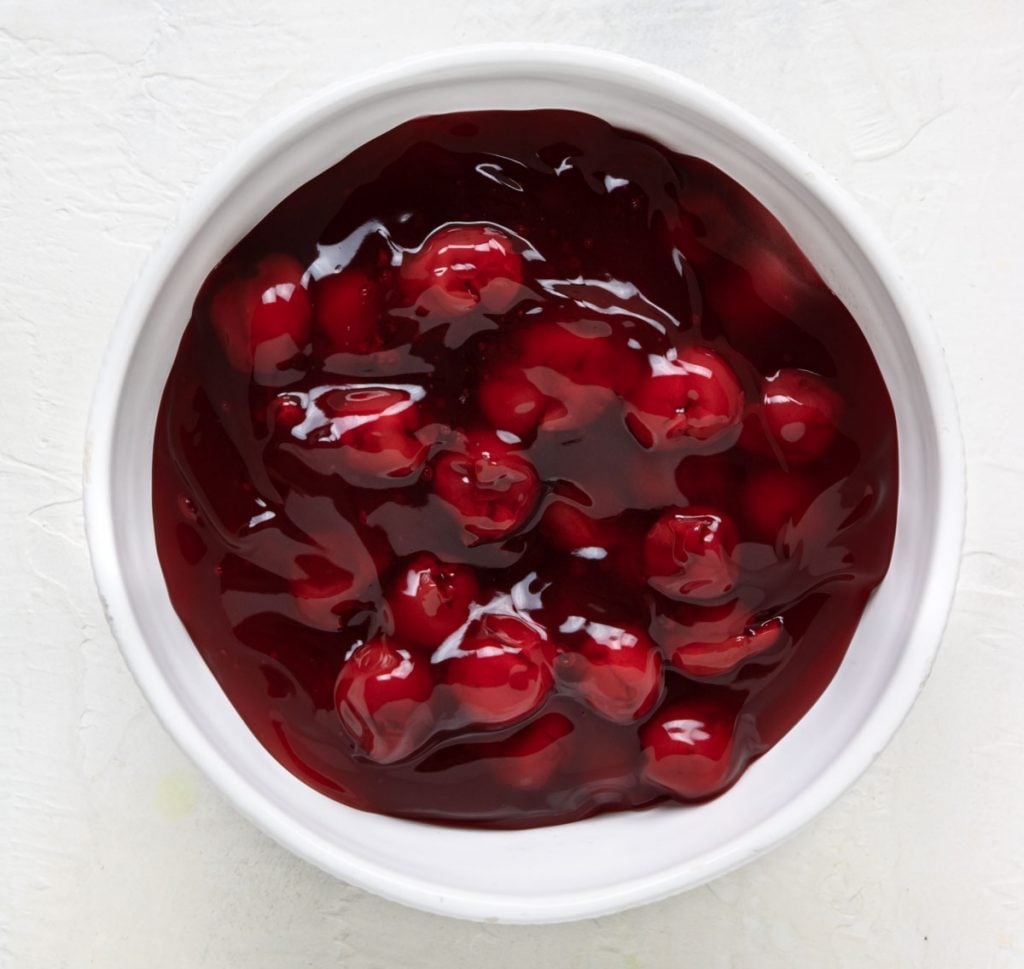 Canned cherry pie filling in a white bowl.