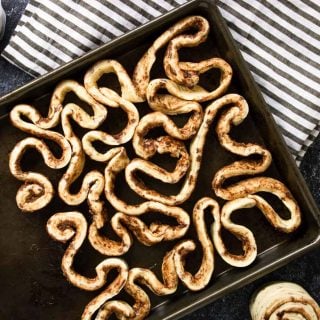 Cinnamon rolls strips coiled and twisted on a baking sheet - looks like intestines