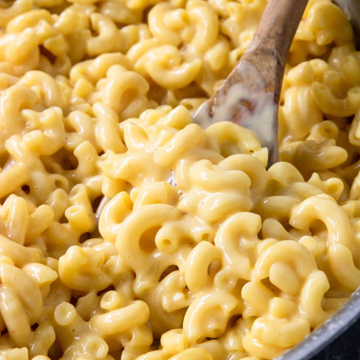 mac and cheese being stirred with a spoon