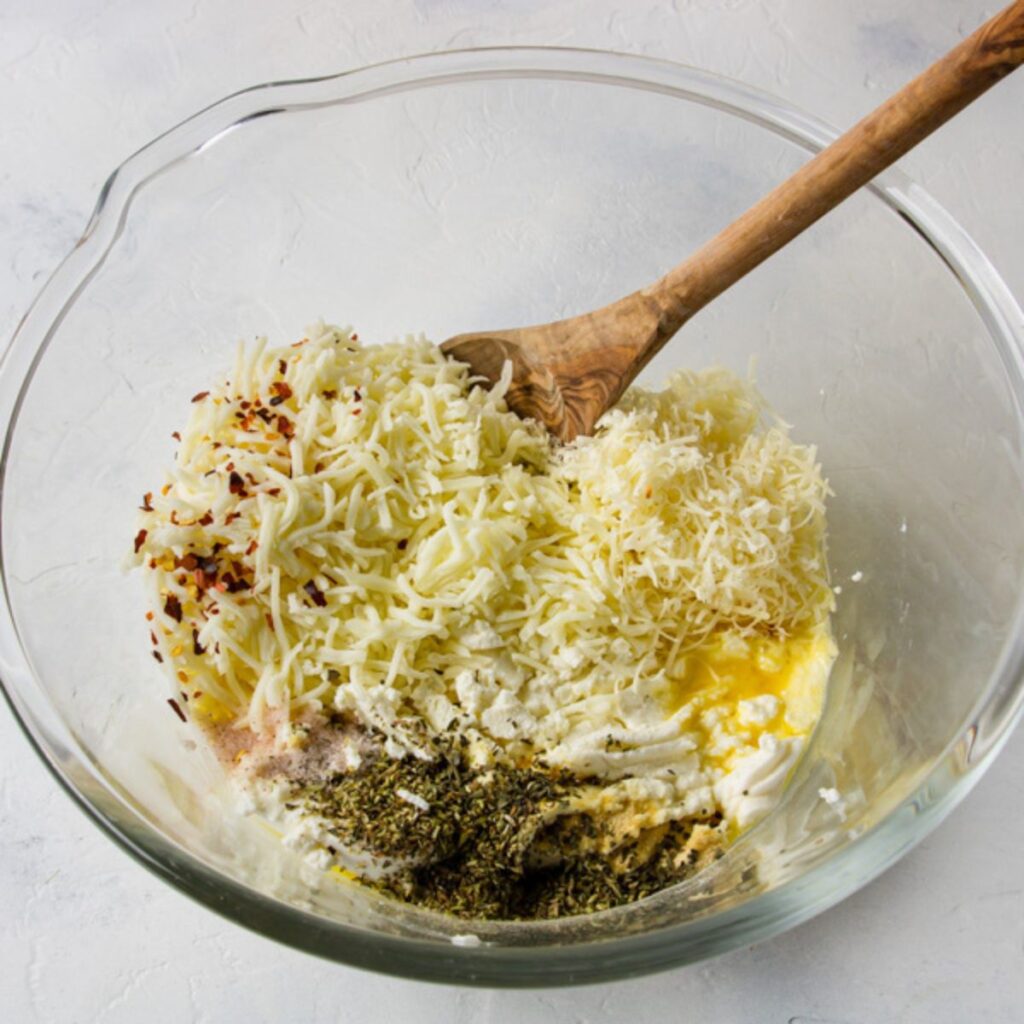 ingredients measured into a bowl to make the filling for stuffed shells with ricotta and spinach