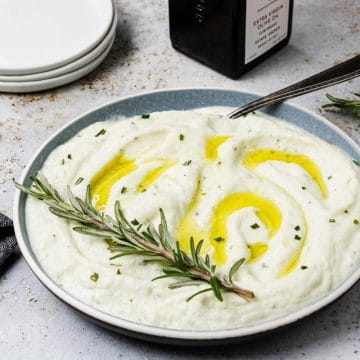Cauliflower Mash in a bowl topped with olive oil and rosemary