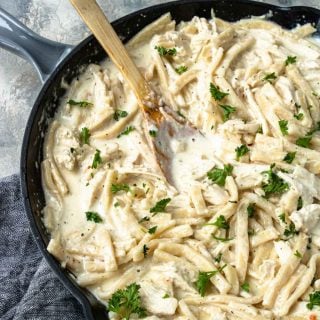 Creamy Chicken and Noodles in a skillet garnished with parsley