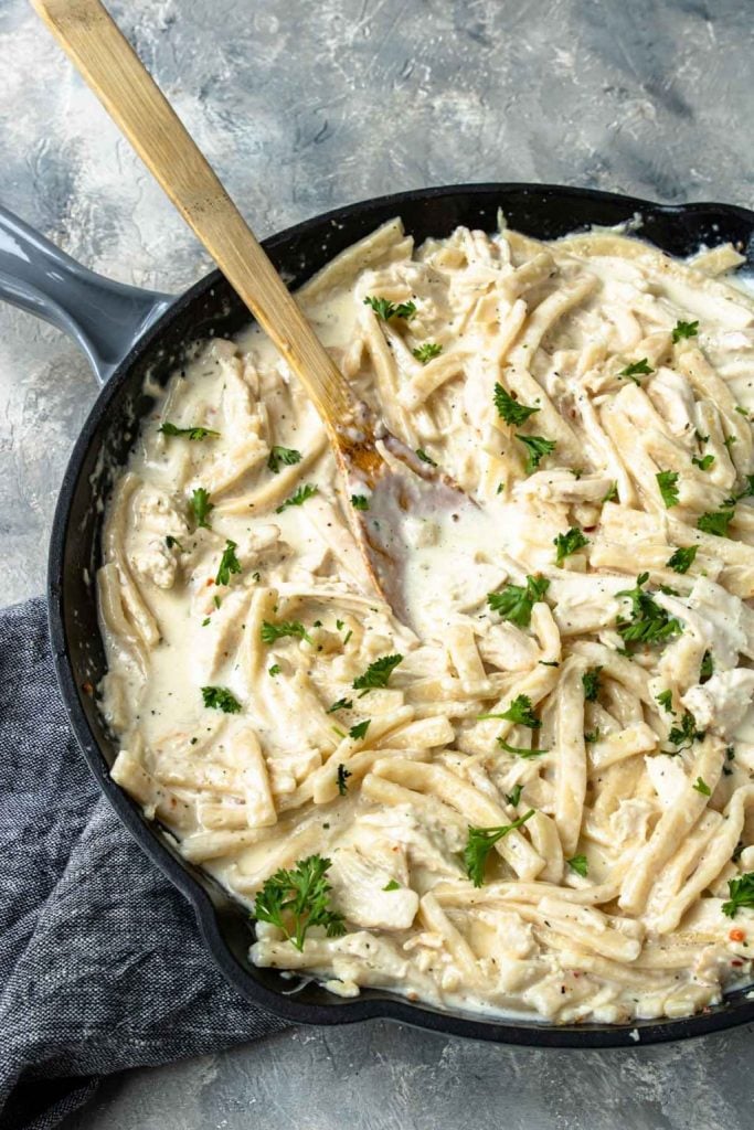 Creamy Chicken and Noodles in a skillet garnished with parsley