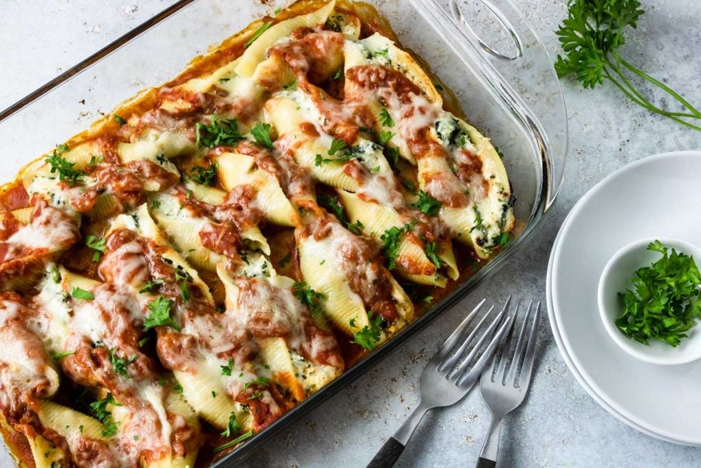Baked Ricotta and Spinach Stuffed Shells in a 9x13 dish with parsley sprinkled on top