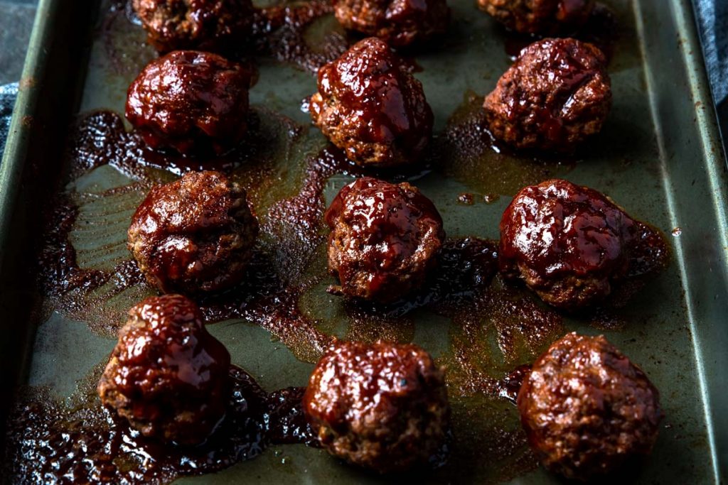 BBQ Meatballs on a baking sheet with bbq sauce caramelized over top
