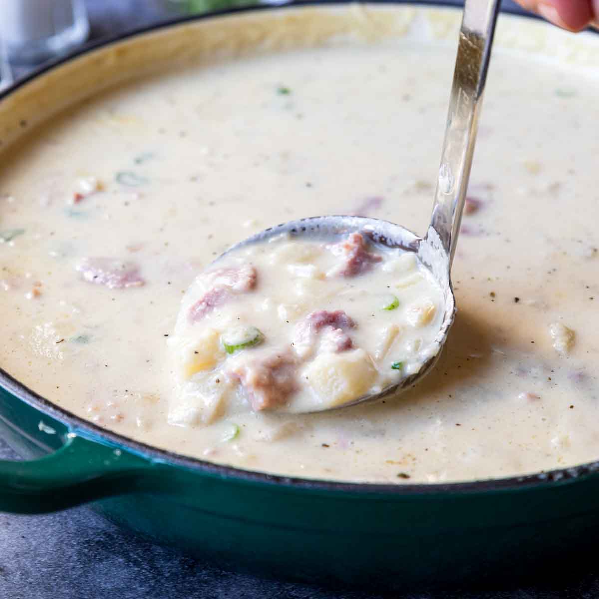 a ladle spooning out a portion of potato ham chowder