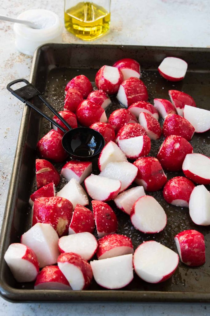 radishes on a baking sheet sprinkled with salt and olive oil